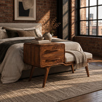 Mid century bench with a two drawer cabinet end and a cushioned seat in an industrial loft bedroom with exposed brick