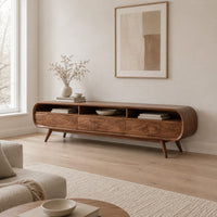 Low tv stand with pill shaped ends, three open cubbies and slim tapered legs in a Scandinavian living room with white walls
