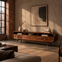 Low tv stand with pill shaped ends, three open cubbies and slim tapered legs in an industrial loft living room with exposed brick
