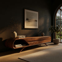 Mid century TV console with a rounded open end on splayed legs in a living room at golden hour
