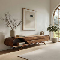 Mid century TV console with a rounded open end on splayed legs in a bright modern living room