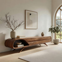 Mid century TV console with a rounded open end on splayed legs in an open plan space in daylight