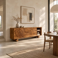 Sideboard with a carved monstera leaf door and an open end shelf in a bright open plan dining room