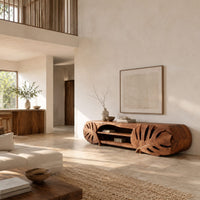 Long tv stand with monstera leaf carved ends and open shelves in the center in a bright open plan living room