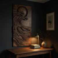 Dark wooden wall relief of a moon over waves above a desk in a dark study corner