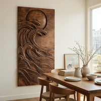 Dark wooden wall relief of a moon over waves beside a dining table in natural light