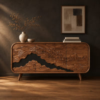 Mountain relief carved sideboard with a dark band and tapered legs in a dark studio against a charcoal plaster wall