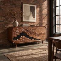 Mountain relief carved sideboard with a dark band and tapered legs in an industrial loft dining room with exposed brick
