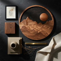 Detail of round wooden mountain wall hanging with a black sky beside wood, brass and linen samples