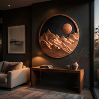 Round wooden mountain wall hanging with a black sky above a low console in an evening living room