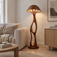 Mushroom canopy floor lamp with a slender sculpted stem and disc base in a Scandinavian living room with white walls