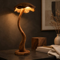 Corner detail of floor lamp with a winding wooden stem and a wavy mushroom cap shade beside wood, brass and linen samples