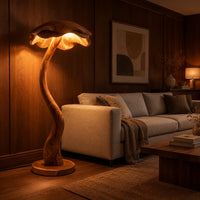 Floor lamp with a winding wooden stem and a wavy mushroom cap shade in an evening living room with walnut wall paneling