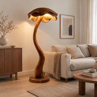 Floor lamp with a winding wooden stem and a wavy mushroom cap shade in a Scandinavian living room with white walls