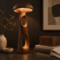 Corner detail of mushroom floor lamp with a domed cap and tall carved stem beside wood, brass and linen samples