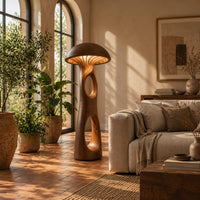 Mushroom floor lamp with a domed cap and tall carved stem in a bright living room with arched windows and plants