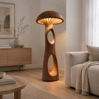 Mushroom floor lamp with a domed cap and tall carved stem in a Scandinavian living room with white walls