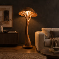 Mushroom floor lamp with a slim curving stem and a ribbed glowing cap in a dark living room at golden hour