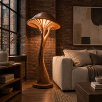 Mushroom floor lamp with a slim curving stem and a ribbed glowing cap in an industrial loft living room with exposed brick