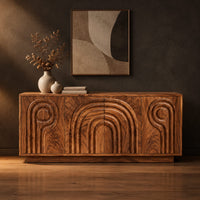 Sideboard with nested arch carving and spiral motifs on four doors in a dark studio against a charcoal plaster wall