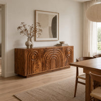 Sideboard with nested arch carving and spiral motifs on four doors in a Scandinavian dining room with white walls
