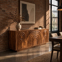 Sideboard with nested arch carving and spiral motifs on four doors in an industrial loft dining room with exposed brick