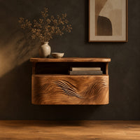 Floating nightstand with a carved wave front and an open nook under the top in a dark studio against a charcoal plaster wall