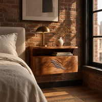 Floating nightstand with a carved wave front and an open nook under the top in an industrial loft bedroom with exposed brick