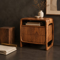 Corner detail of nightstand with an open top cubby and a looped side frame beside wood, brass and linen samples