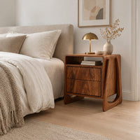 Nightstand with an open top niche and sculpted loop shaped sides in a Scandinavian bedroom with white walls