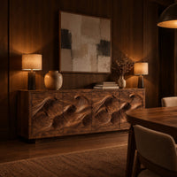 Low sideboard with four carved wave relief panels on a plinth base in an evening dining room with walnut wall paneling