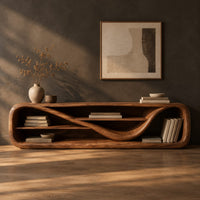 Corner detail of low open capsule shaped media console with a winding shelf running through it beside wood, brass and linen samples