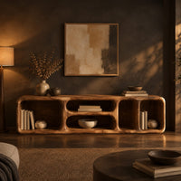 Low tv stand with soft edges and a stacked pair of oval cubbies in a dark living room at golden hour