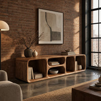 Low tv stand with soft edges and a stacked pair of oval cubbies in an industrial loft living room with exposed brick