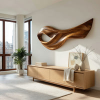 Open eye swoosh wooden wall sculpture above a light oak sideboard in daylight