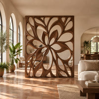 Room divider with a large open flower pattern of sweeping petals in a bright open-plan living room with arched windows and plants