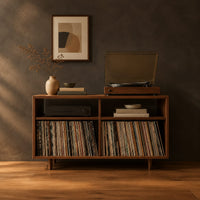 Open turntable stand with four square bays and short tapered legs in a dark studio against a charcoal plaster wall