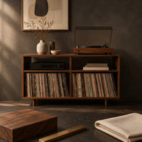 Corner detail of open turntable stand with four square bays and short tapered legs beside wood, brass and linen samples