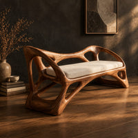 Wooden bench with a pale cushioned seat and an organic open frame, three-quarter view showing the grain