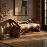 Wooden bench with a pale cushioned seat and an organic open frame in an industrial loft entryway with exposed brick