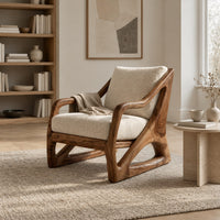 Armchair with a sculpted open wood frame and cream cushions in a Scandinavian living room with white walls
