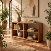 Open frame console table with four cubbies and soft edges in a bright entryway with arched windows and plants