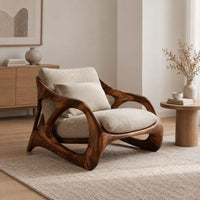 Open frame wooden lounge chair with thick sculpted loops and cream cushions in a Scandinavian living room with white walls