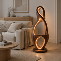 Tall floor lamp shaped as a looping figure eight with a small shelf in a Scandinavian living room with white walls