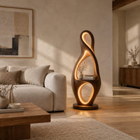 Tall floor lamp shaped as a looping figure eight with a small shelf in a bright open plan living room