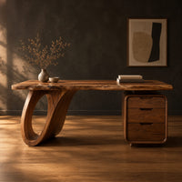 Desk with an open loop leg and a three drawer pedestal in a dark studio against a charcoal plaster wall