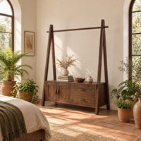 Open rail wardrobe with slanted side posts and a low cabinet base in a bright bedroom with arched windows and plants