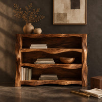 Corner detail of open shelf console table with wavy sculpted sides beside wood, brass and linen samples
