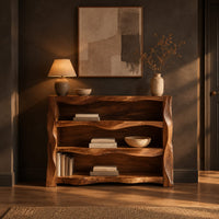 Open shelf console table with wavy sculpted sides in a dark entryway at golden hour
