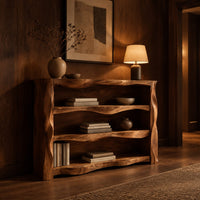 Open shelf console table with wavy sculpted sides in an evening entryway with walnut wall paneling